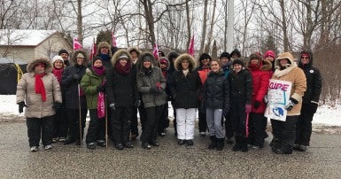 A group of workers holding picket signs