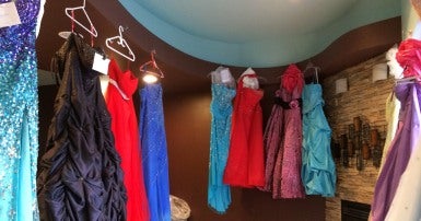 Multi-coloured formal dresses hanging in a row