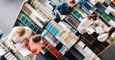 Overhead view of library with book shelves and people reading books