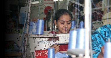 Young woman at a sewing machine in a factory