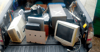 Old broken computer parts in the bed of a truck