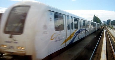 Image of Vancouver SkyTrain, elevated light rapid transit train and track with blue sky in the background.