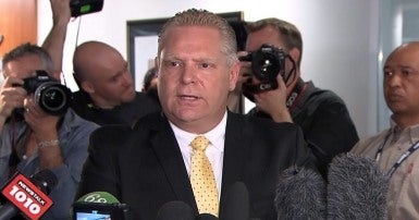 Doug Ford dans une mêlée de presse avec des journalistes.