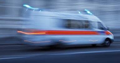 An ambulance travels so fast it is a blur
