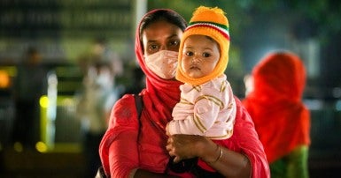 A garment worker on the way out of work with her child in Dhaka, Bangladesh.