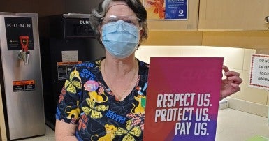 health care worker with sign against Bill 124