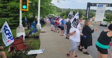 People walking a picket line holding signs