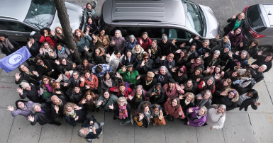 Group gathering on a city street looking up for the camera