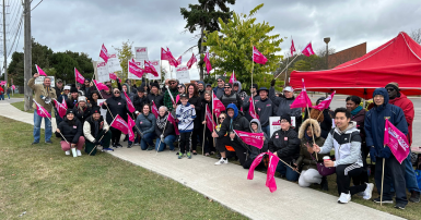 Group of people posing with flags and picket signs