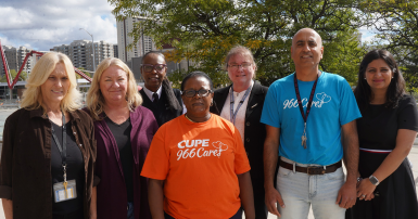 group of people posing for a photo with shirts that say CUPE 966 cares