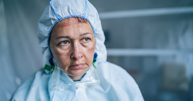 Tired Frontline health care Worker with protective suit during COVID-19