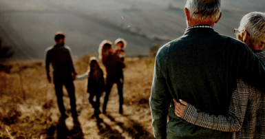 Older couple watch children and grandchildren walking away