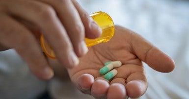 Person emptying a bottle of prescription medicine into their hand