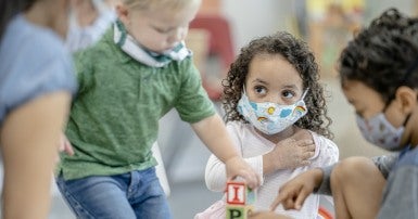 Children playing wearing masks