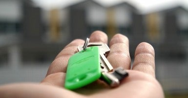 An outstretched hand holds house keys