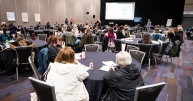 Photo of a group of members participating in a bystander intervention training in a conference hall.