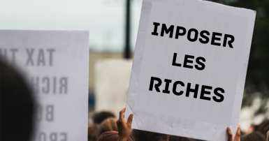Protest sign that reads imposer les riches 