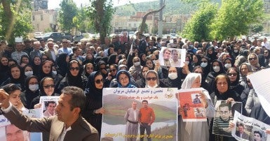 People protesting, holding photos and signs