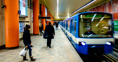 People waiting on a subway platform as the train arrives 