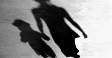 Shadow of woman and girl holding hands
