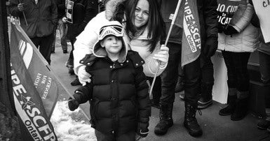 CUPE member and young child rally for education