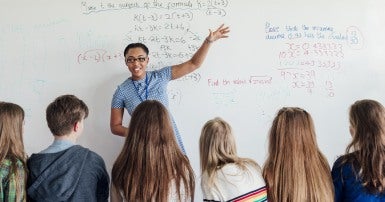 Teacher giving a lesson at a white board