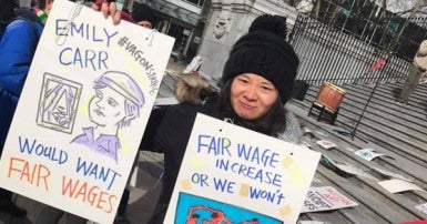 CUPE member with sign outside Vancouver Art Gallery