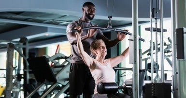 Personal trainer helping older woman