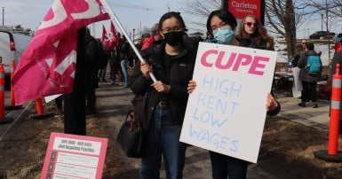 CUPE 4600 members with a picket sign saying High rent, low wages