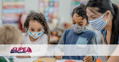 Three children and a childcare worker wearing masks