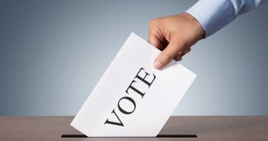 Voter puts ballot in ballot box
