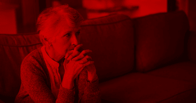Photo of an elderly woman with a worried expression and a red overlay