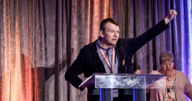 Rory Gill raises fist at CUPE AB convention