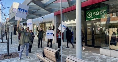 People standing in front of SQDC building with picket signs