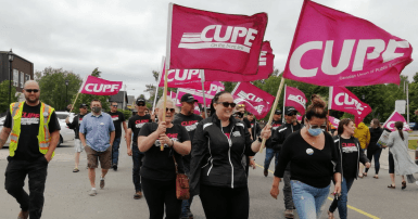 CUPE 1349 members marching with CUPE flags at a rally in Grand Falls-Windsor NL