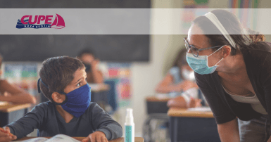 Web banner. Image: Teacher talking to young student at his desk. Both are wearing a face mask. CUPE NS logo.