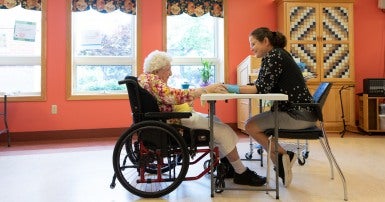 Nursing home worker with client in a wheelchair
