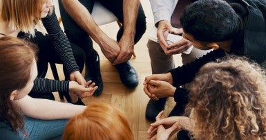 High angle of a group of teenagers sitting in a circle during group therapy