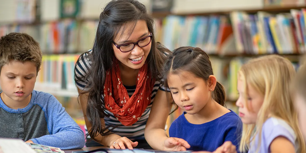 Woman reading books with kids