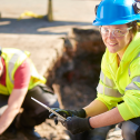 A female municipal worker does roadwork on a residential street.