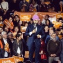 NDP Leader Jagmeet Singh in the centre of a large rally with a Quebec flag as a backdrop