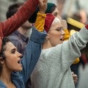 Group of people holding signs and chanting at a demonstration