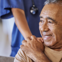 A health care workers places her hand on the shoulder of an elder