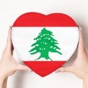 Female hands holding a heart shaped box bearing the Lebanese flag