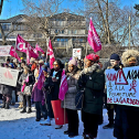 People holding flags and signs at a rally