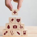 Hand arranging wood block stacking with healthcare icons