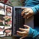 Woman at home with a computer on her lap on a video conference call