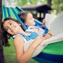 Two children reading in a hammock