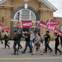 CUPE 1349 members carrying CUPE flags march in front of town hall in Grand Falls-Windsor NL