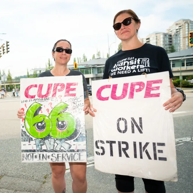 Picketer holding "On strike" sign